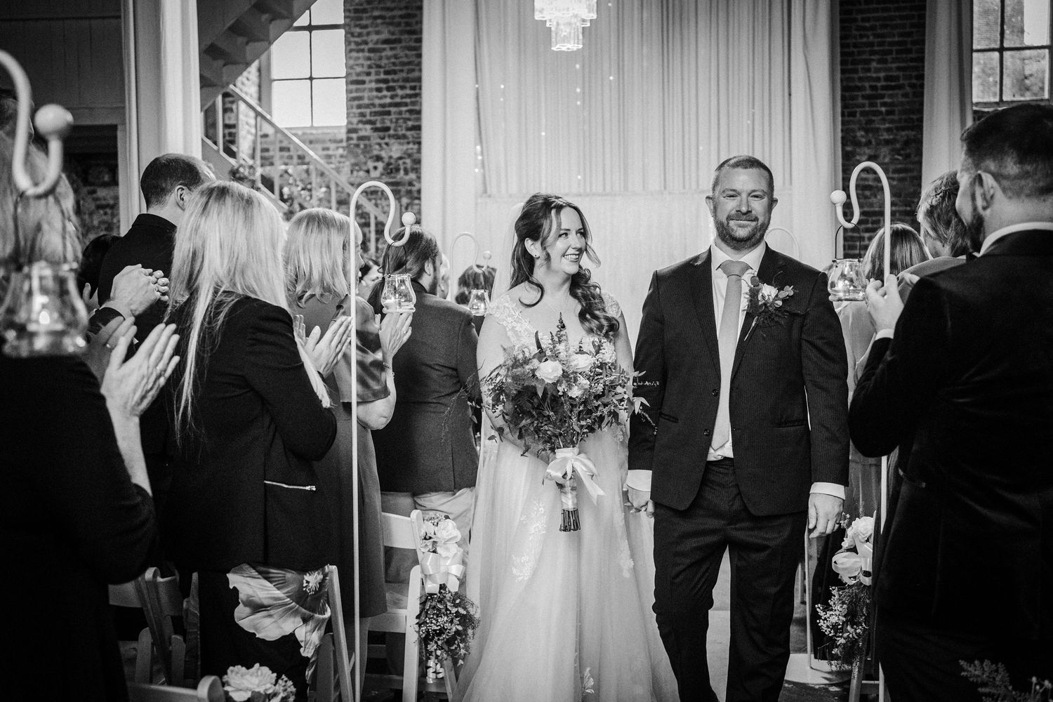 Wedding party and guests mingle during an elegant indoor reception.
