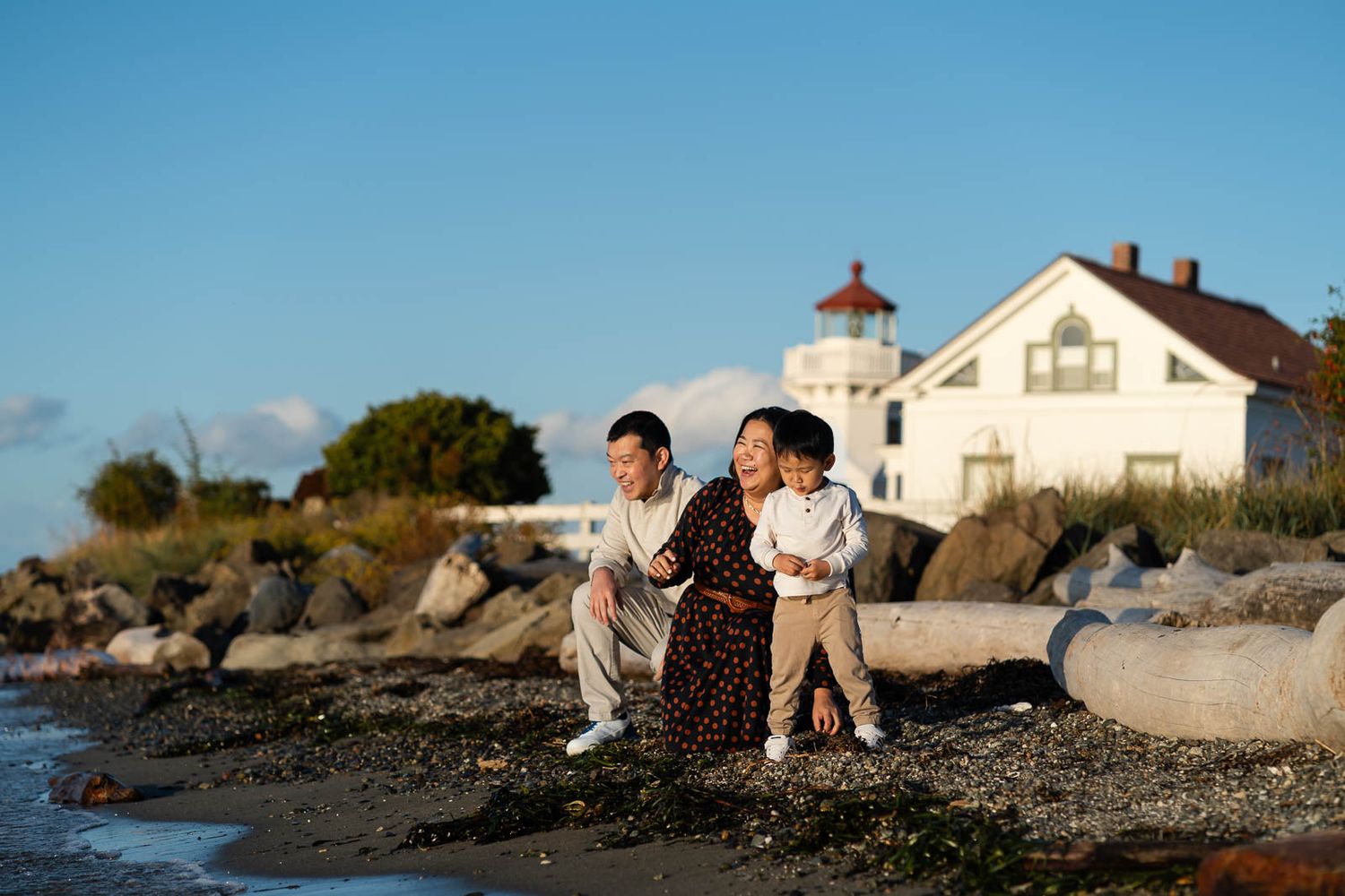 Family playing by the beach at sunset.