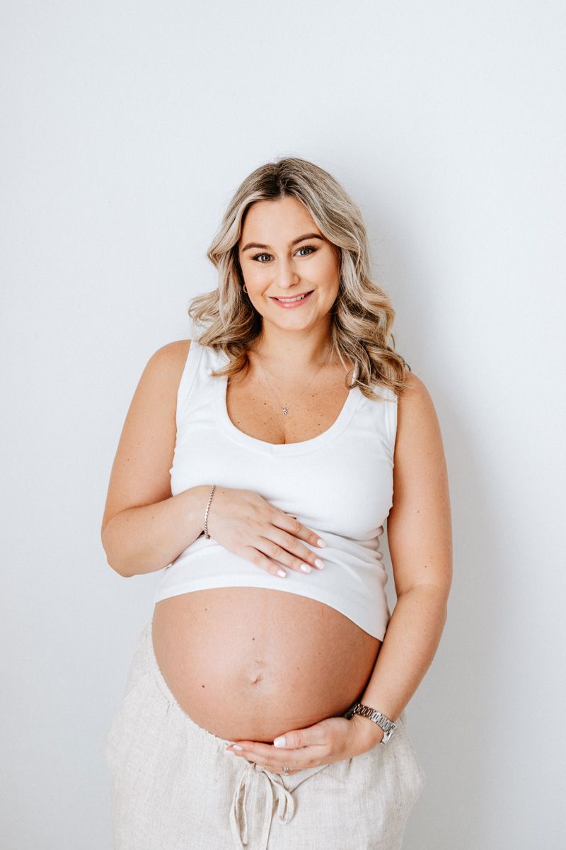 A series of maternity photos showing a pregnant figure in white against a light background.