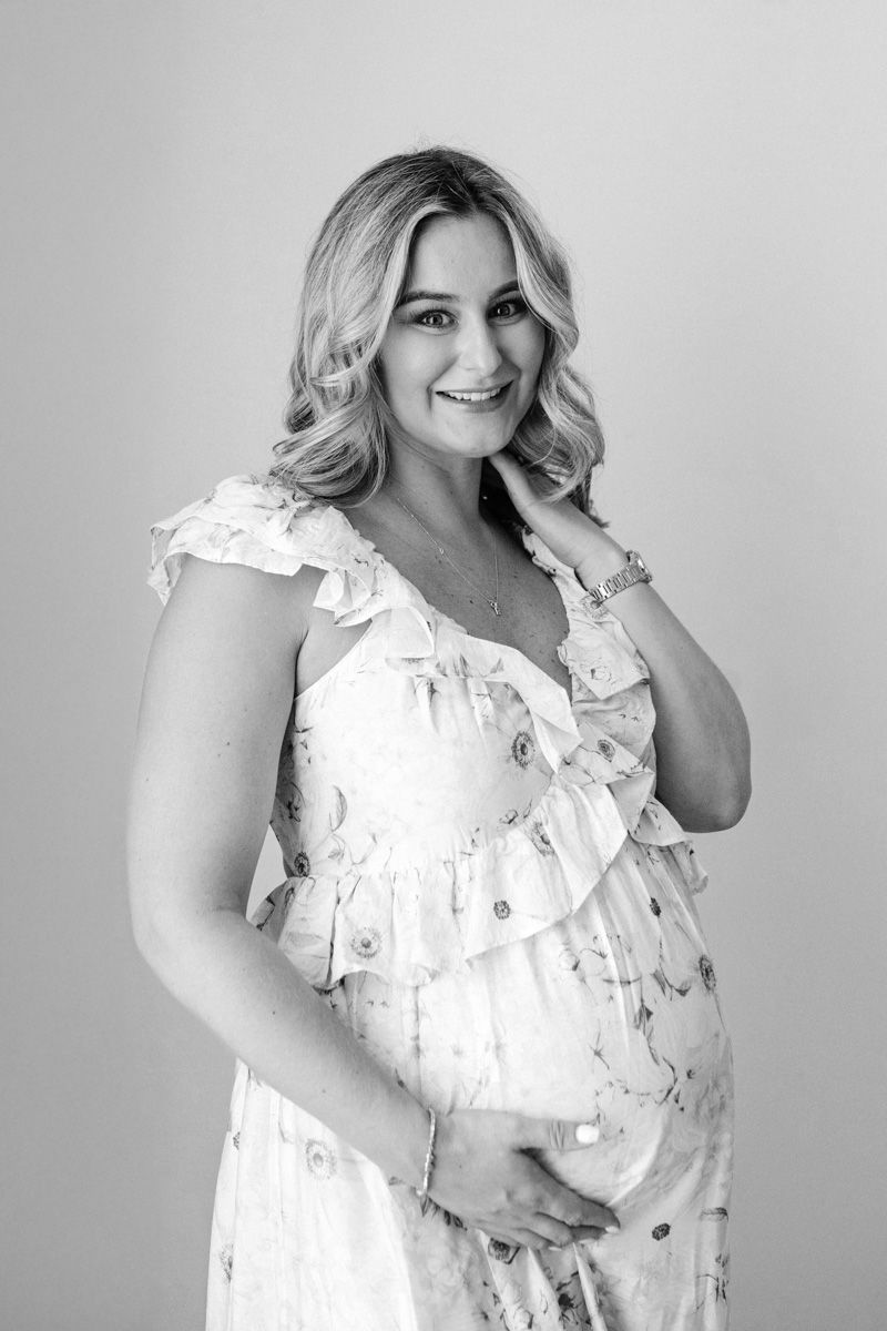 A series of black and white portraits showing someone in a white ruffled dress posing playfully against a light background.