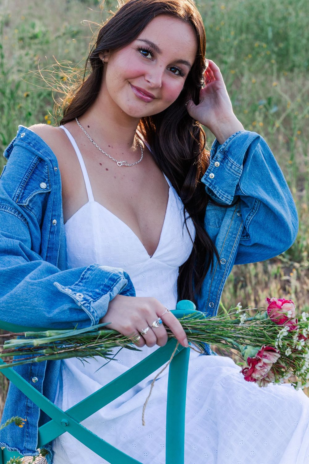 Simi High School senior posing in a grassy field with cowboy boots and guitar for outdoor senior portraits in Simi Valley.