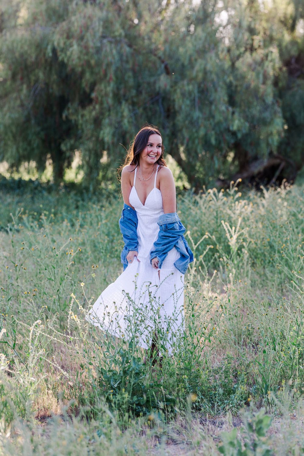 Simi High School senior posing in a grassy field with cowboy boots and guitar for outdoor senior portraits in Simi Valley.