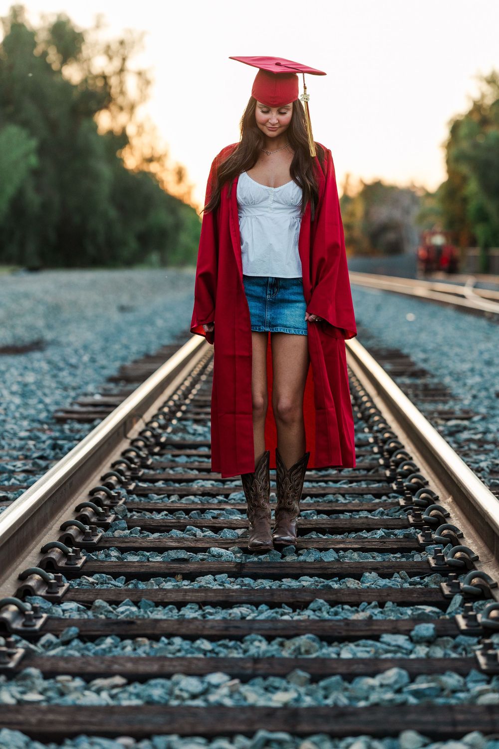 Simi High School senior posing in a grassy field with cowboy boots and guitar for outdoor senior portraits in Simi Valley.