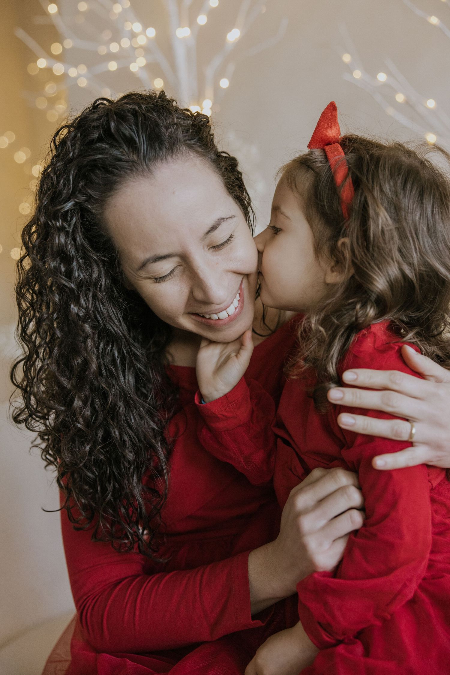 A sweet moment captured in a series of photos showing affectionate embraces between parent and child in matching red outfits.