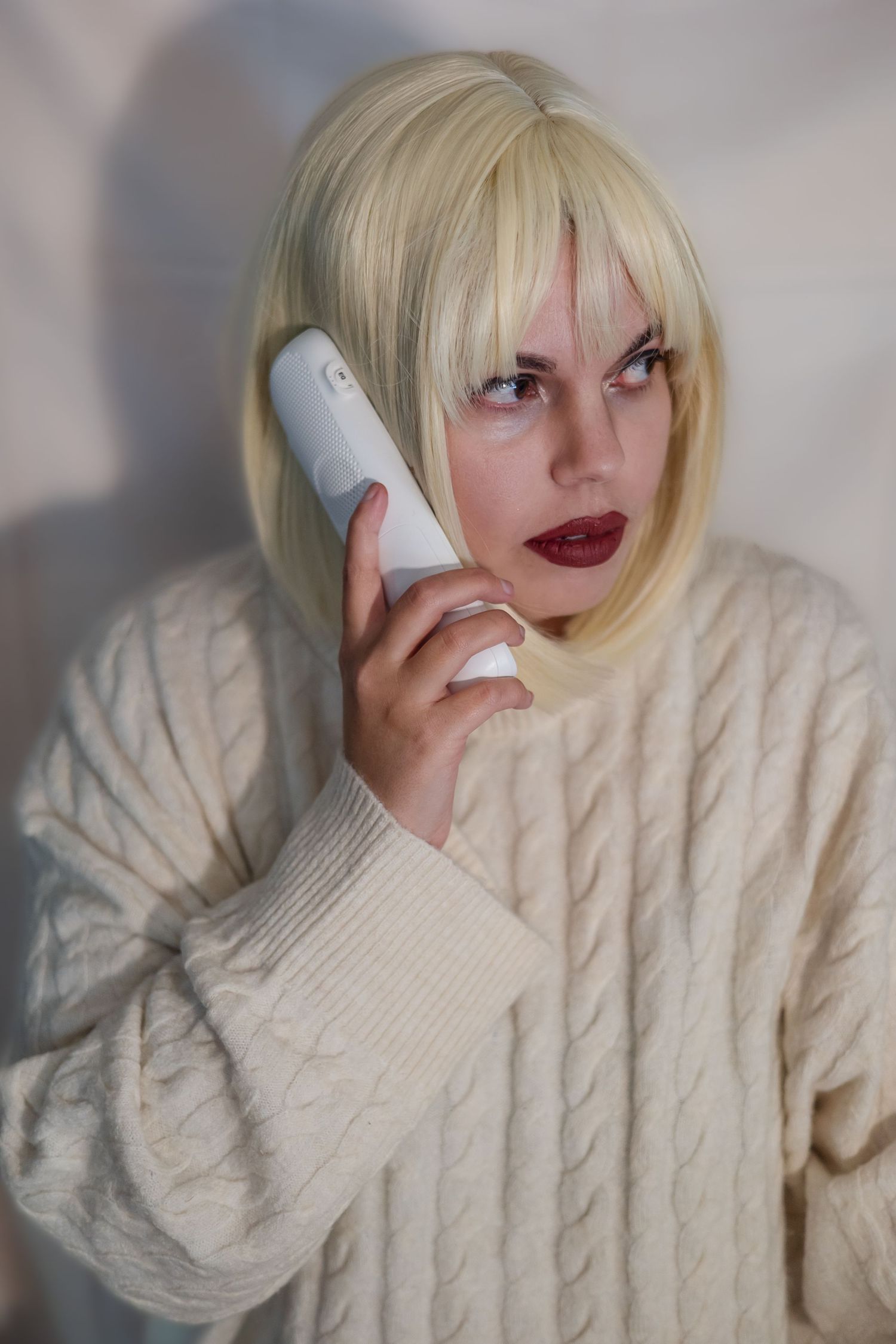 A person wearing a cream cable knit sweater poses with various expressions in a photo collage series.