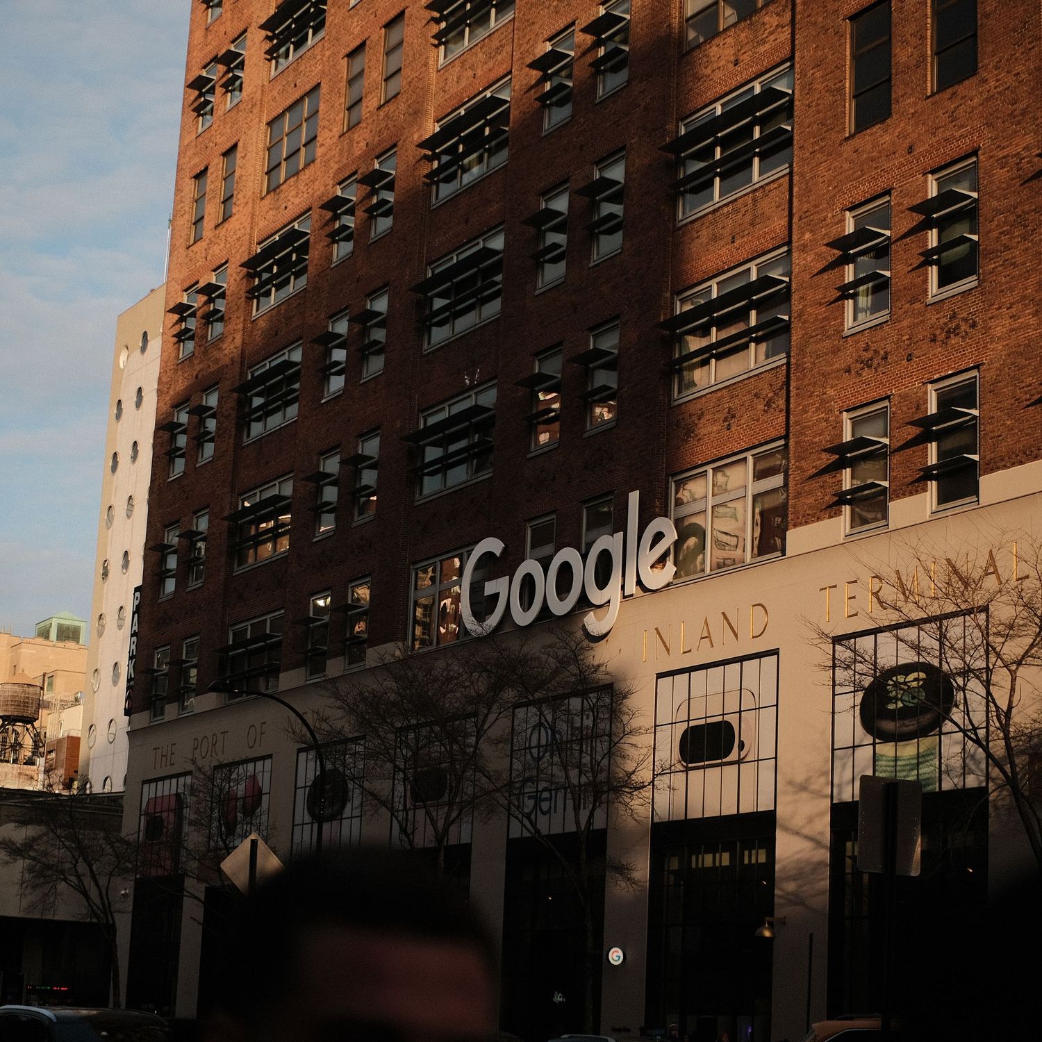 Google logo on the facade of a historic brick building in an urban setting.