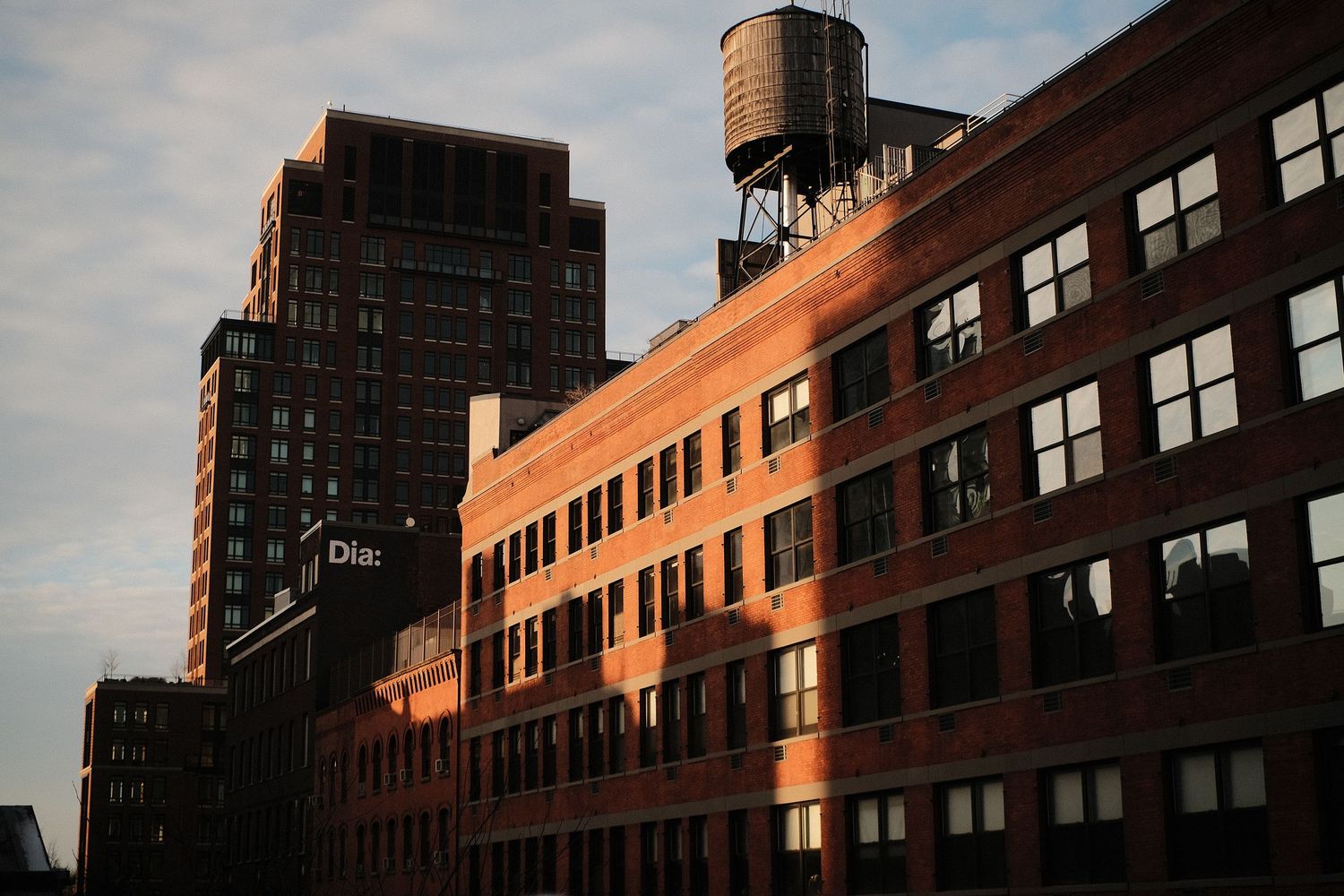 Brick buildings catching golden sunset light in urban setting.