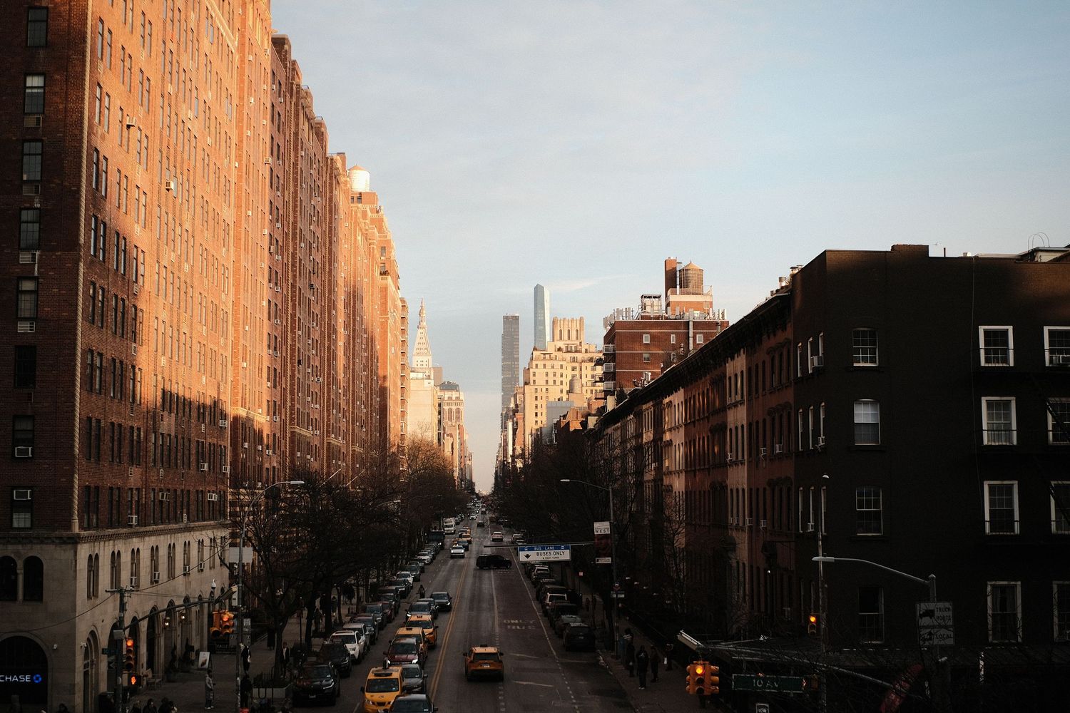 Street view of brick apartment buildings during sunset in city neighborhood.