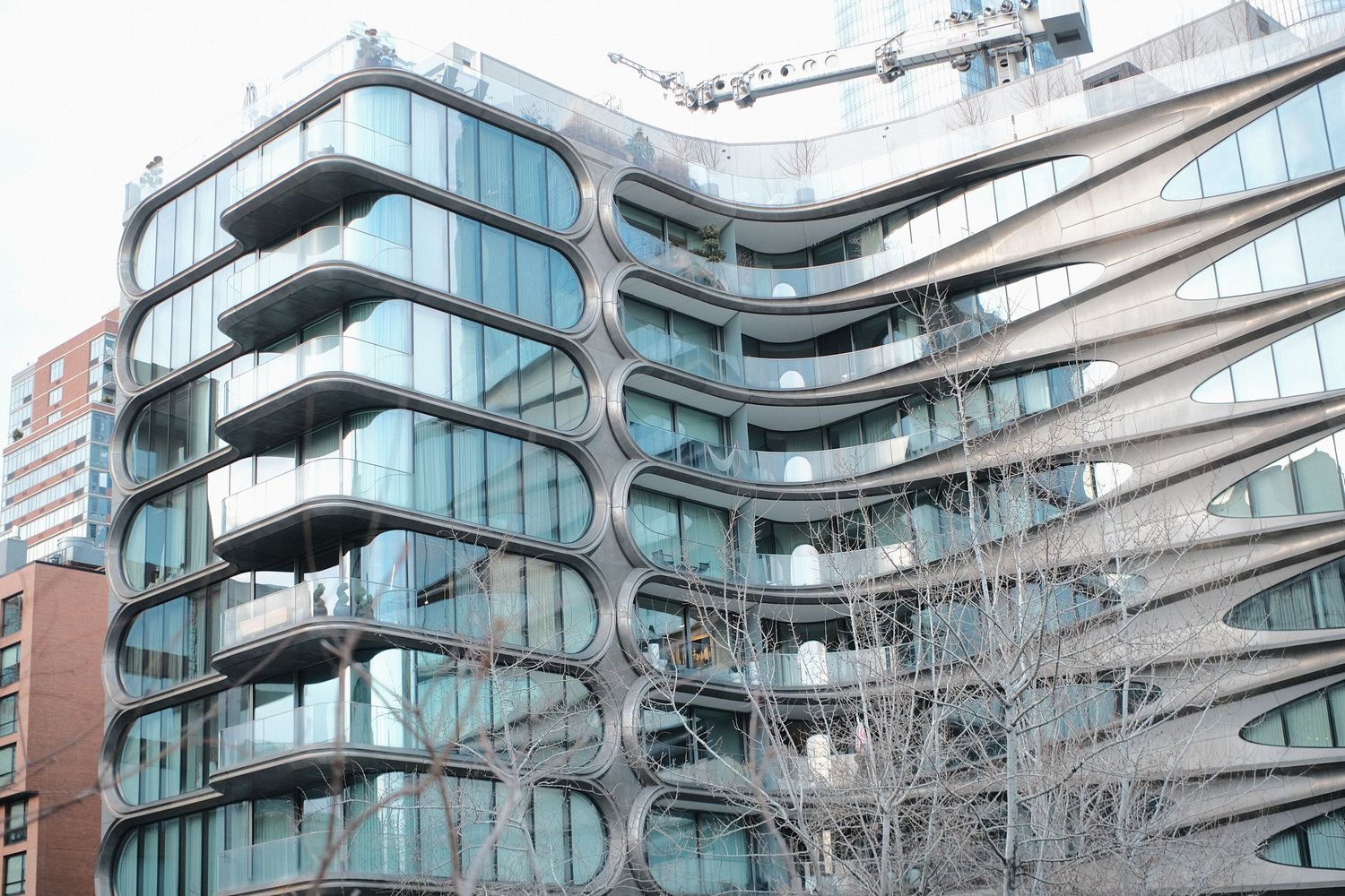 Modern apartment building exterior featuring curved glass balconies and contemporary architectural design.