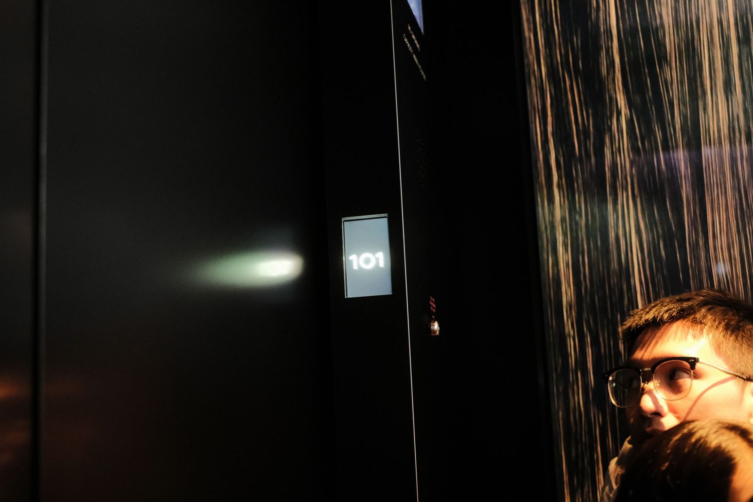 Dark interior space with vertical light streaks creating an atmospheric effect.