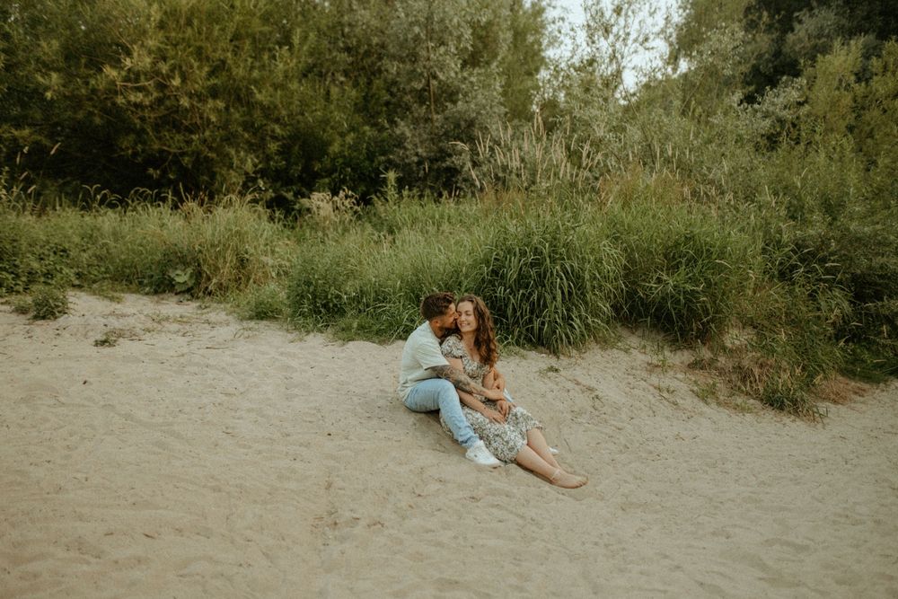 Candid shots of a couple sharing tender moments on a beach with greenery in the background.