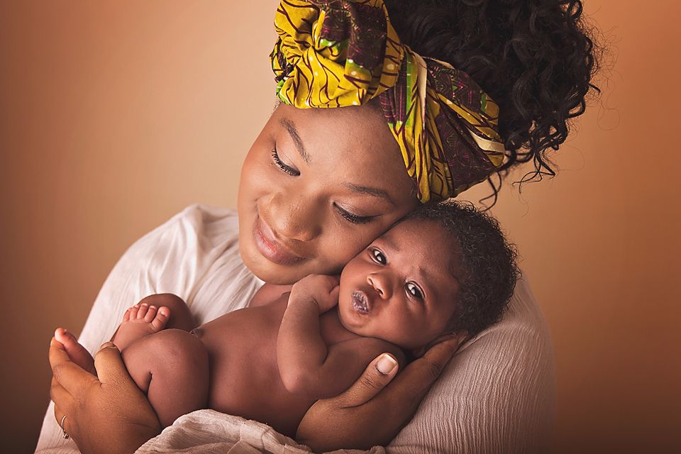 A tender moment captured in warm lighting as a parent and child share affectionate kisses and embraces.