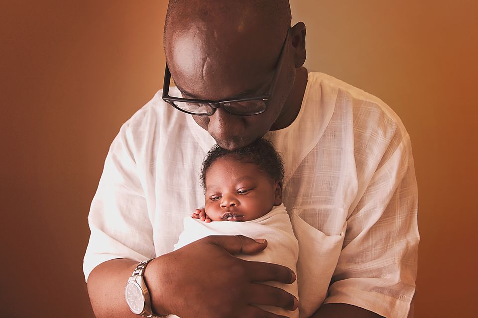 A series of intimate black and white photos showing tender moments between a parent and baby.