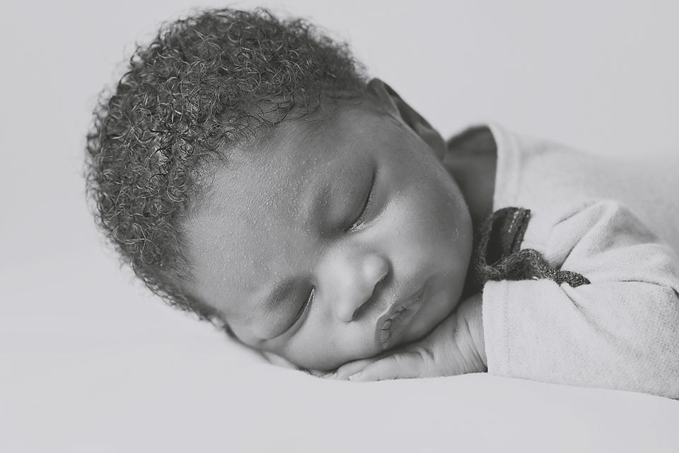 A series of black and white close-up photographs showing a sleeping infant's face from different angles.