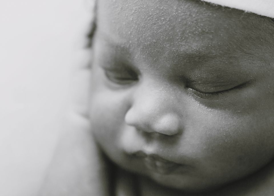 Black and white close-up portraits of a peaceful sleeping baby's face with soft lighting.