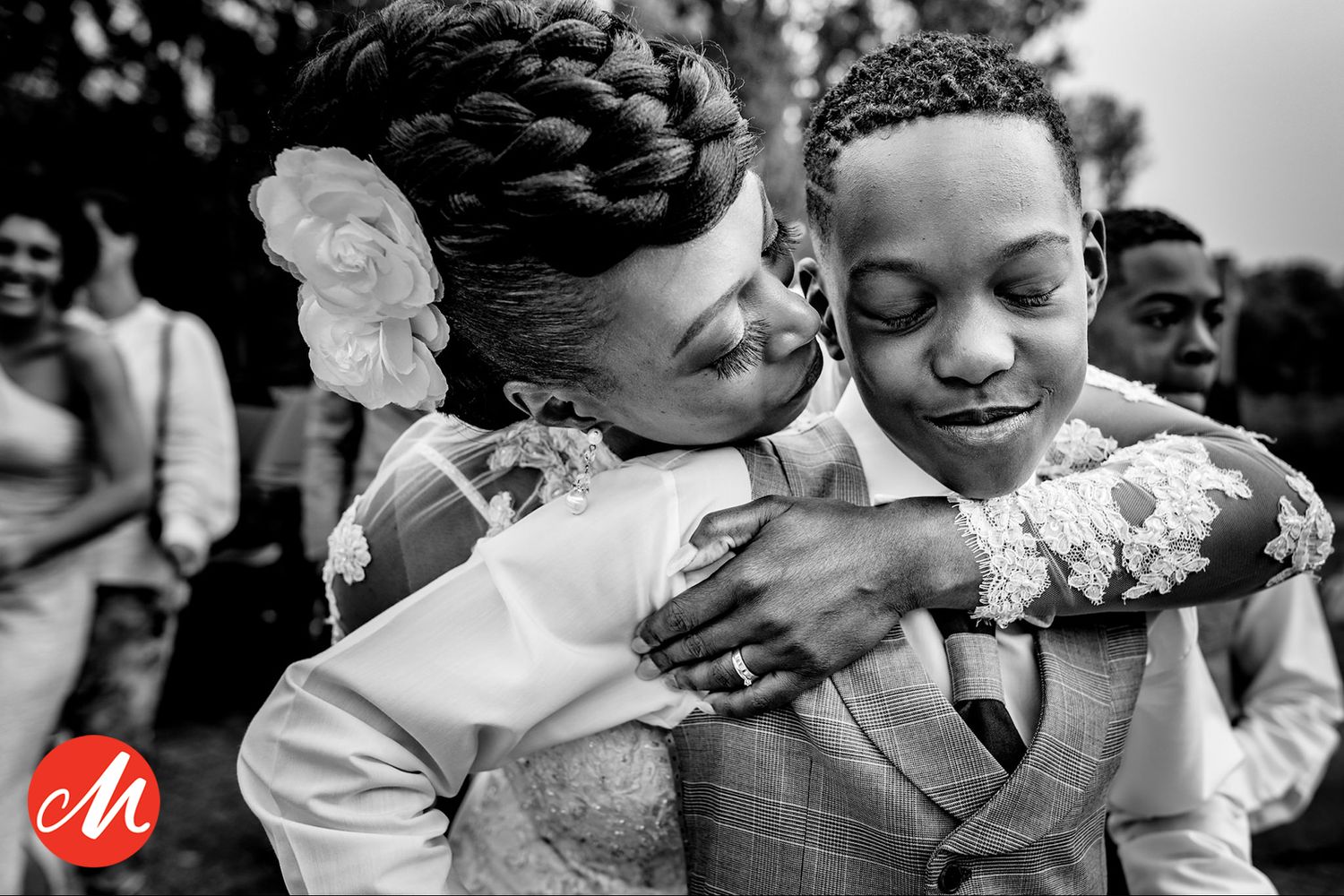 Two people share an emotional embrace during a joyful wedding celebration.