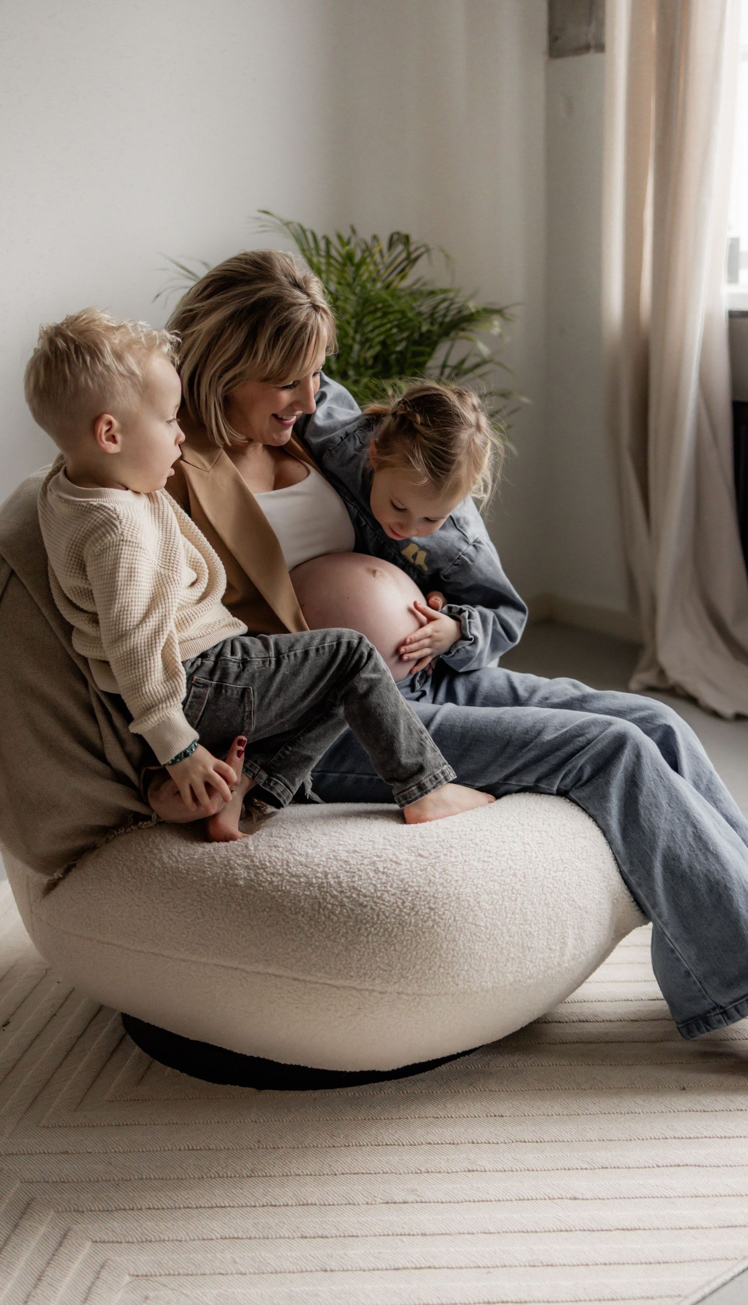 Family moment captured on white cushion by window with natural lighting.