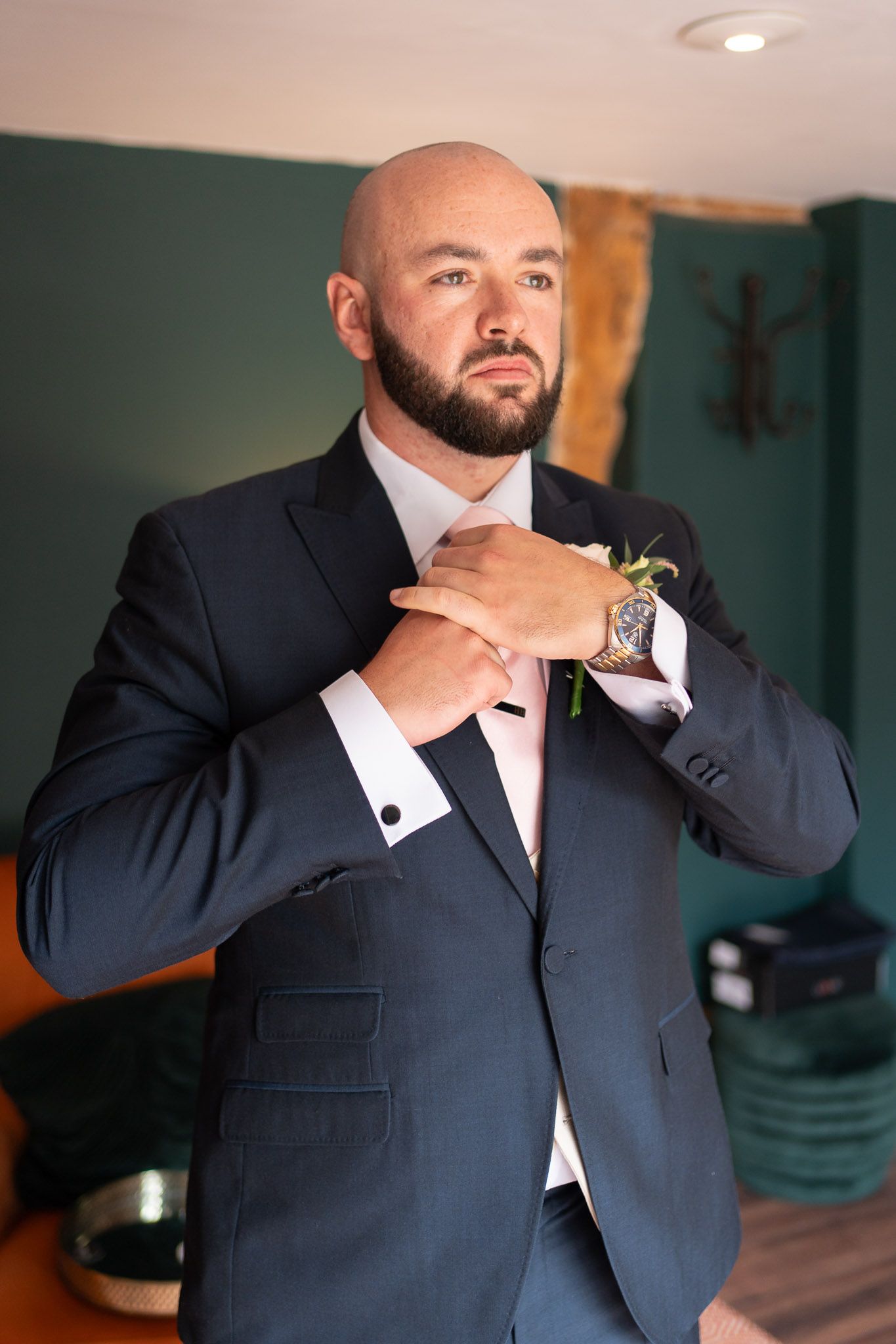 A series of photos showing someone adjusting their tie and collar while wearing a dark navy suit and white dress shirt.