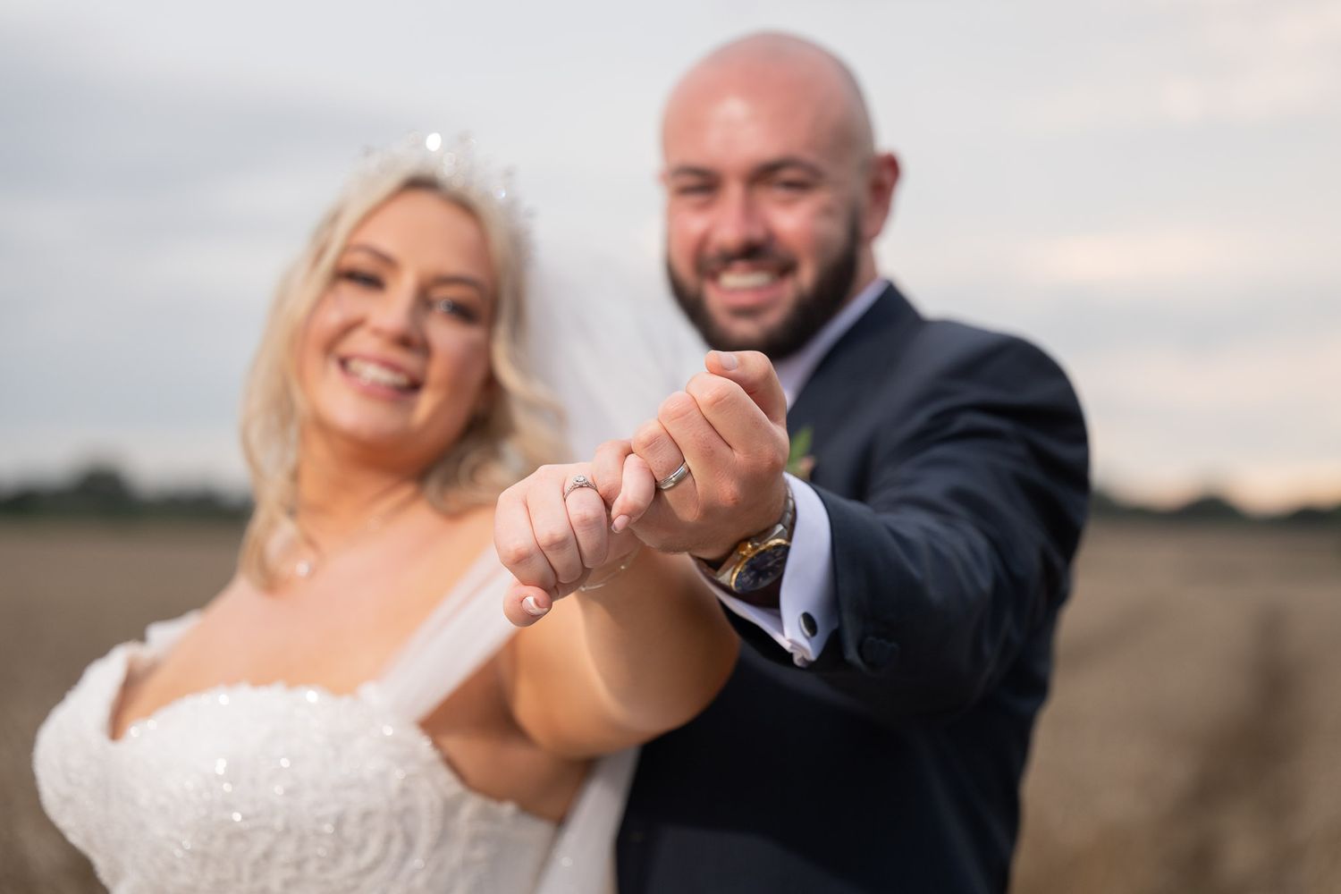 A romantic outdoor photoshoot of a couple dancing together in a scenic natural setting during sunset.