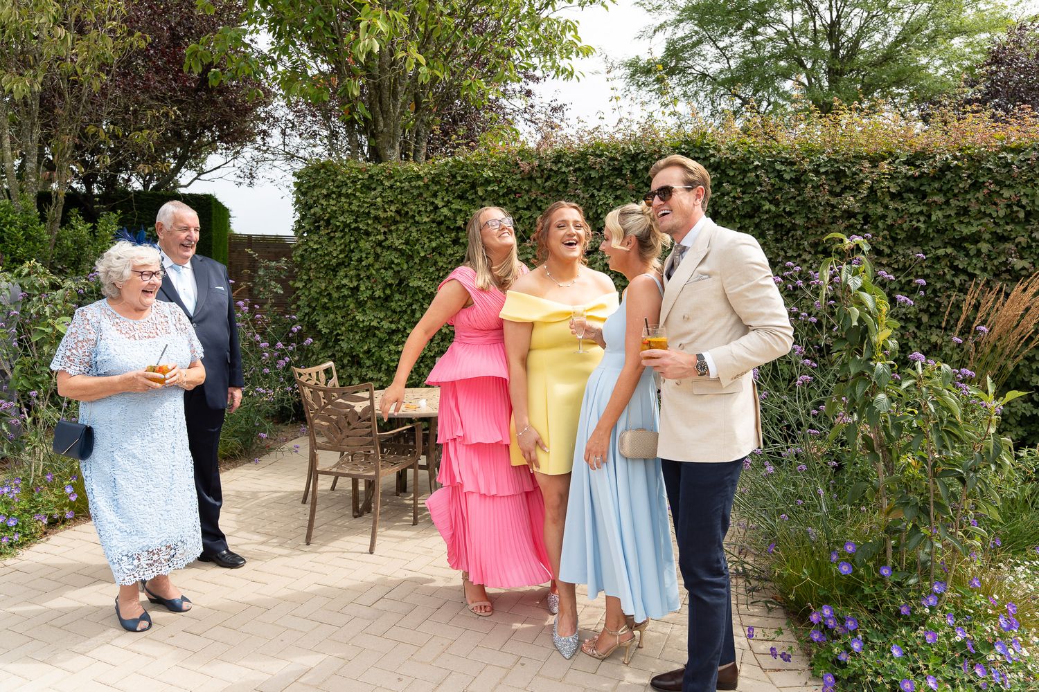 A series of outdoor garden party scenes showing people mingling and socializing in a lush green setting.