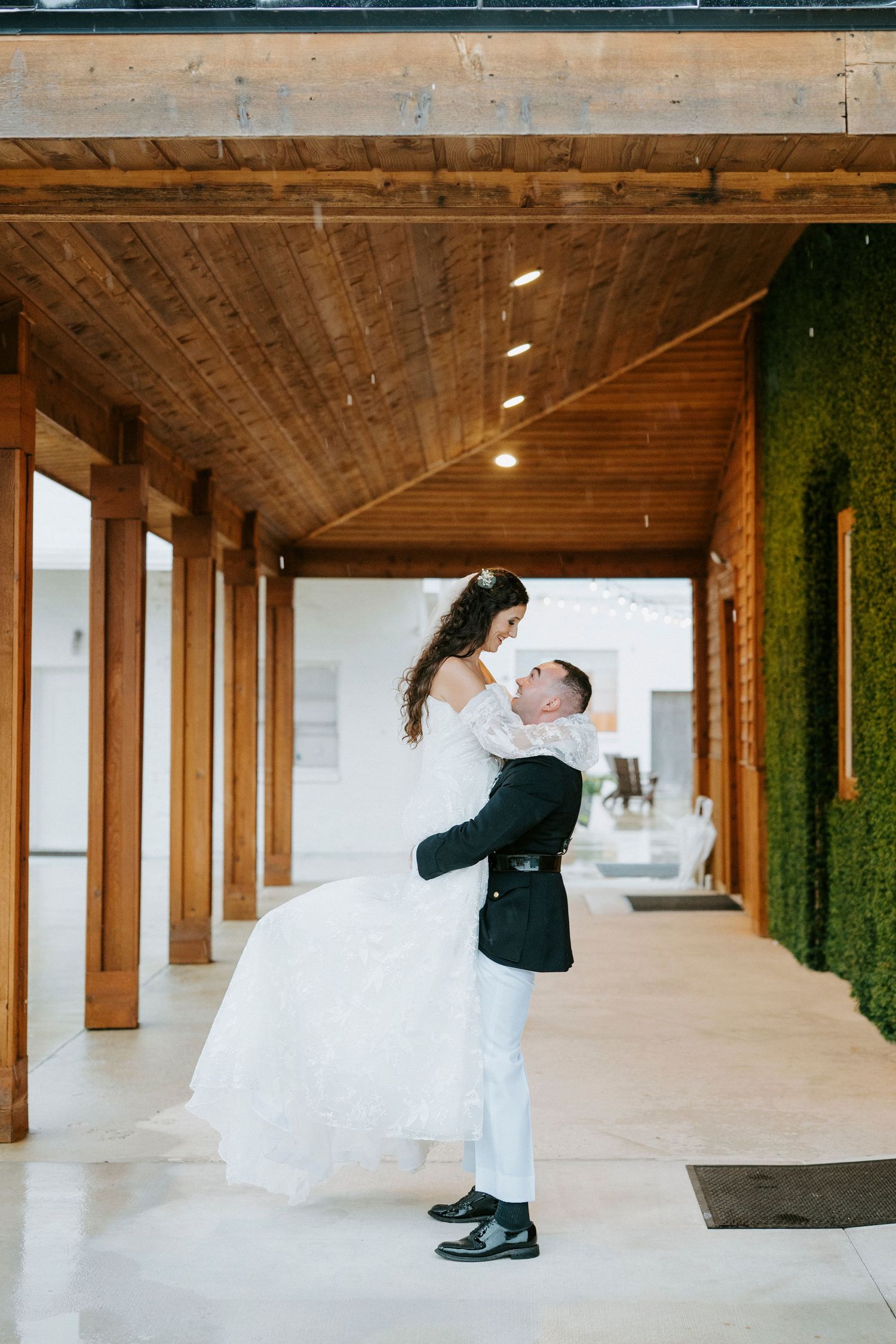 Couple sharing romantic dance moves in an elegant indoor venue with wooden beams and green accent walls.