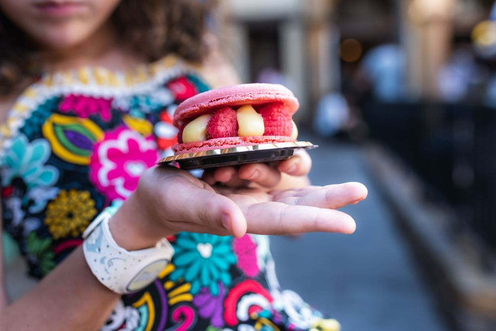 A colorful array of French macarons in various flavors and pastel colors arranged in a decorative display.