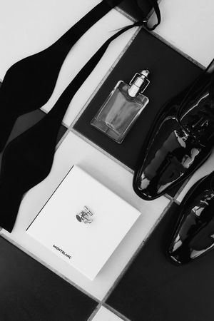 Minimalist black and white product photography composition showing luxury perfume bottles and retail packaging.