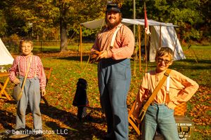 Autumn campsite scene with historical reenactors and white canvas tents.