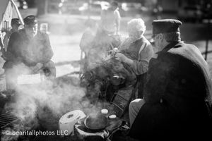 Black and white photograph showing smoky atmosphere at historical reenactment camp.