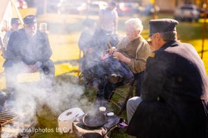 Smoky campfire scene with golden sunlight at historical reenactment gathering.