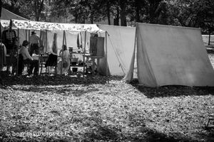 Row of white canvas tents set up for Civil War reenactment in black and white.