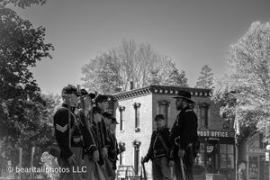 Civil War reenactors in period uniforms standing in front of a historic building.