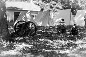 Black and white panorama of Civil War era tents and cannons set up in a wooded area.