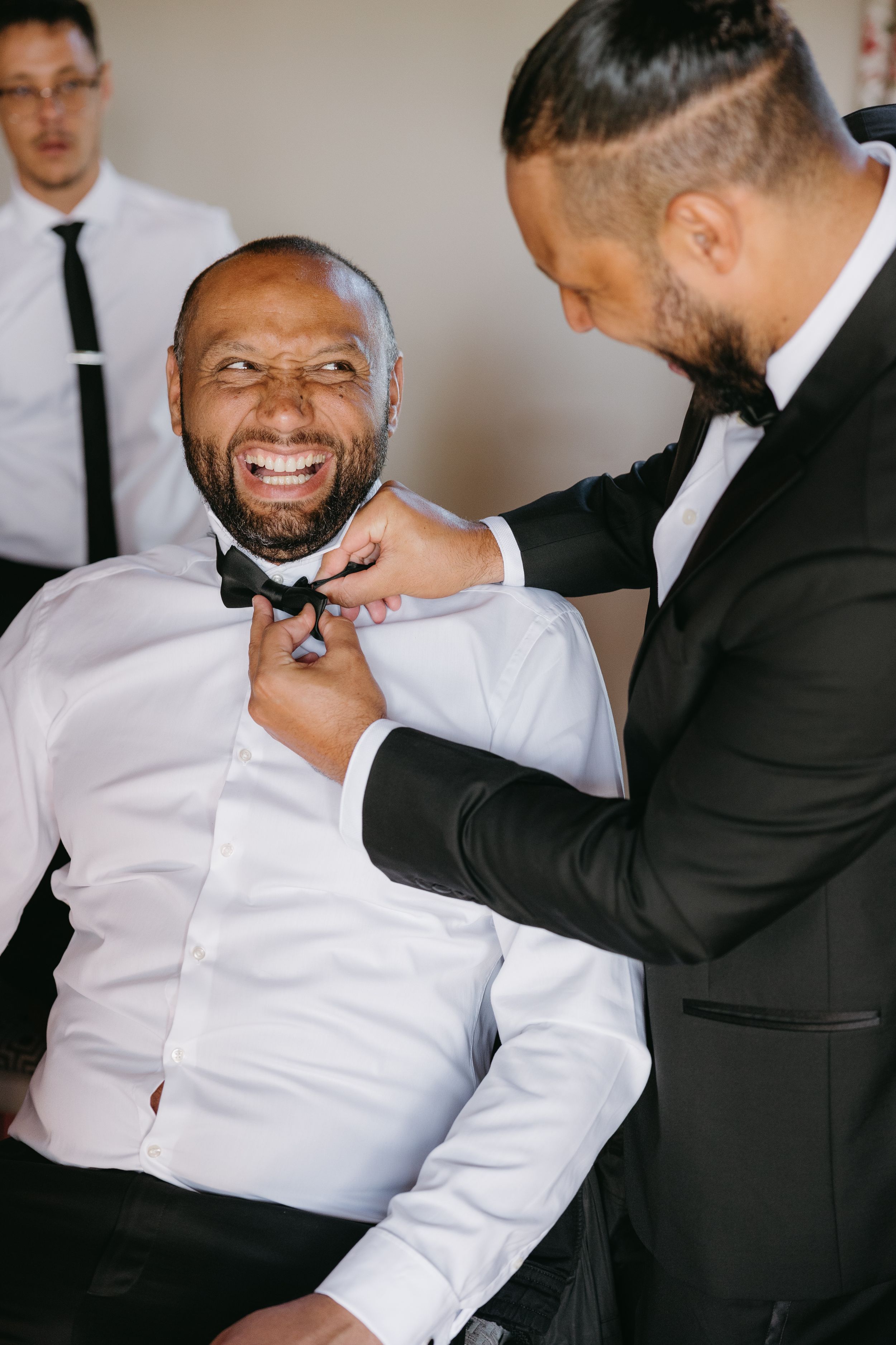 A sequence of candid moments showing two people in formal attire sharing laughter and playful interaction.