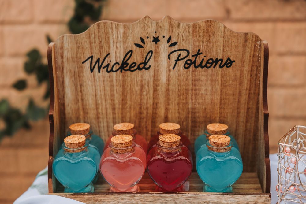 Colorful glass bottles arranged in a wooden display case with rustic farmhouse style decor.