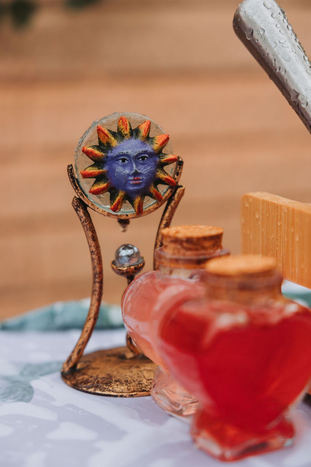 A sequence of cocktail photos showing a decorative blue sun-face garnish on a glass with red liquid.
