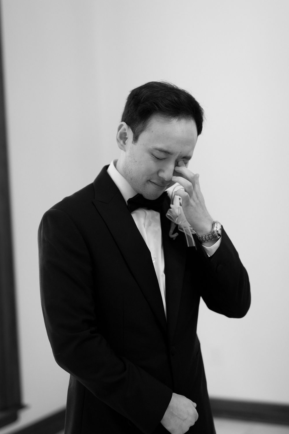Black and white photo series showing a person in a suit expressing different emotional reactions while talking on phone.