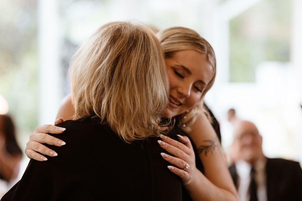 A couple in formal attire share an intimate embrace and dance together at an indoor event.