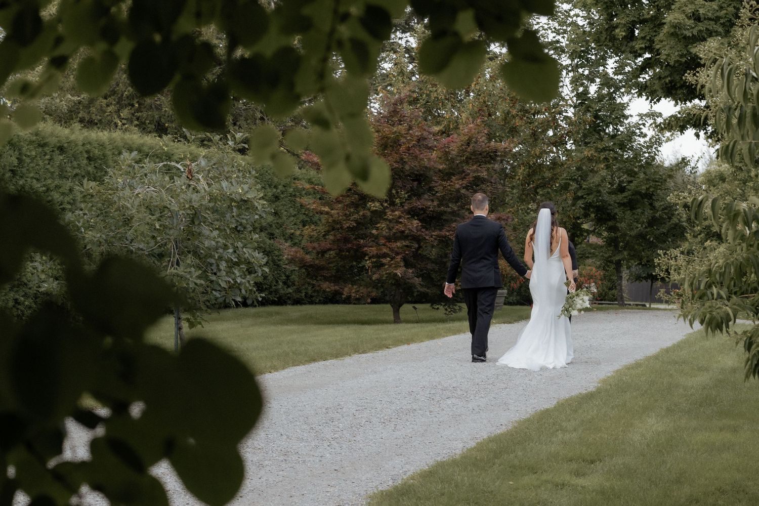 bride running away through field at sunset in an outdoor summer wedding in Nova Scotia, timeless elegant wedding photography