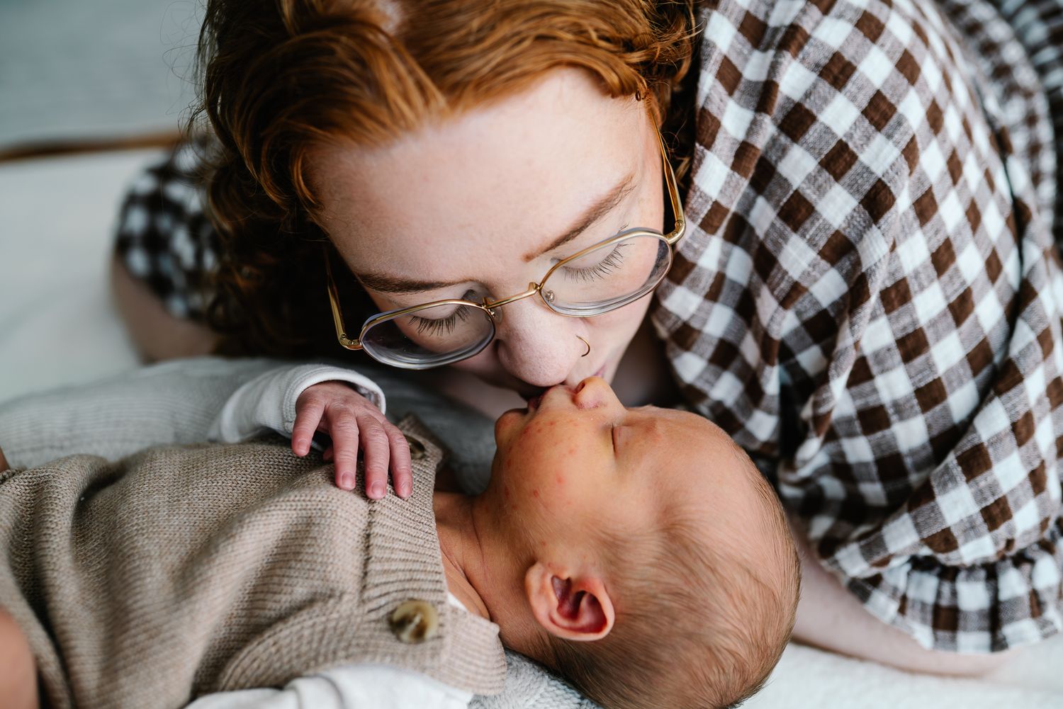 A tender moment between mother and baby captured in soft lighting taken by Melbourne maternity and newborn photographer
