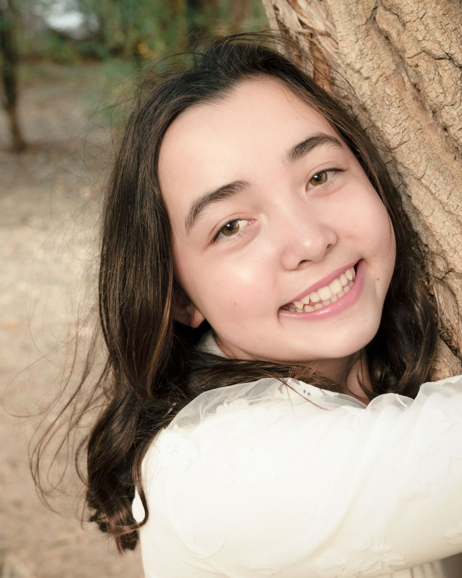 A series of close-up portrait shots showing warm smiles and natural expressions against a soft outdoor background.
