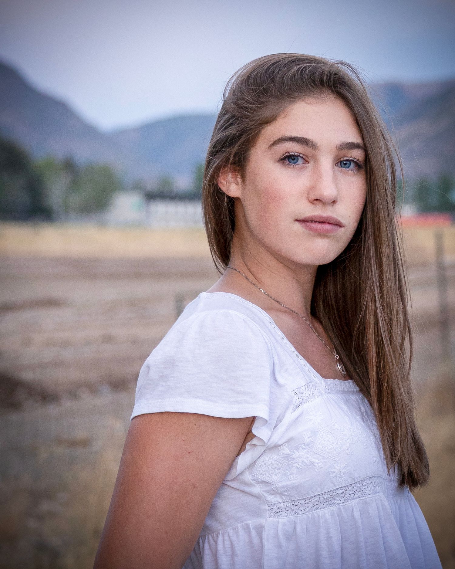 A series of outdoor portrait photos showing a young person in a white top against a natural backdrop with mountains.
