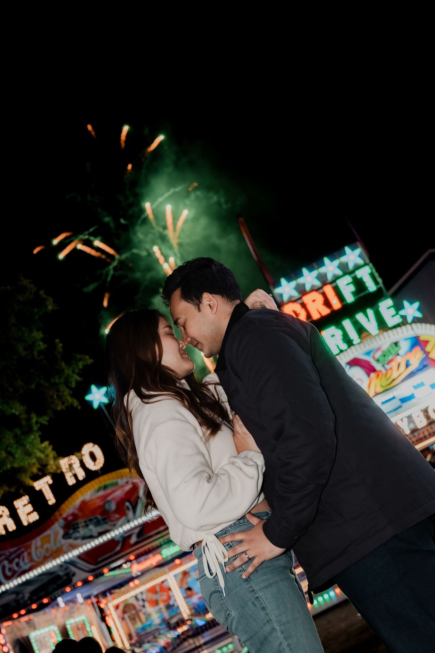 Romantic nighttime scene at an amusement park with colorful neon lights in the background. Australia