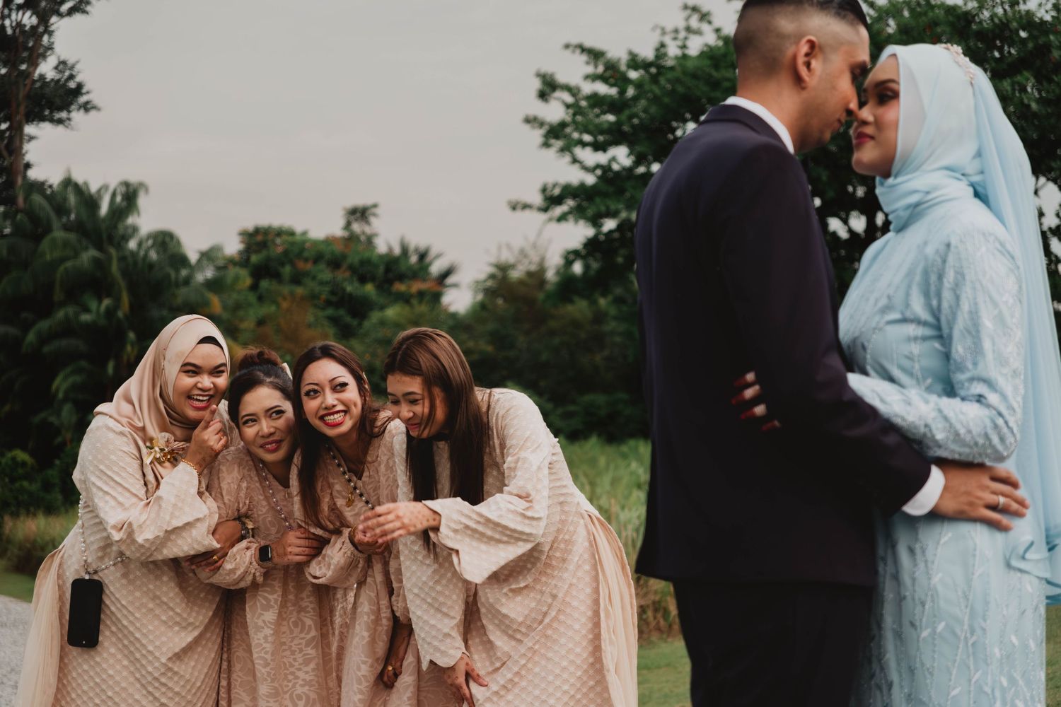 Wedding party in blush dresses and formal attire posing together outdoors. Singapore