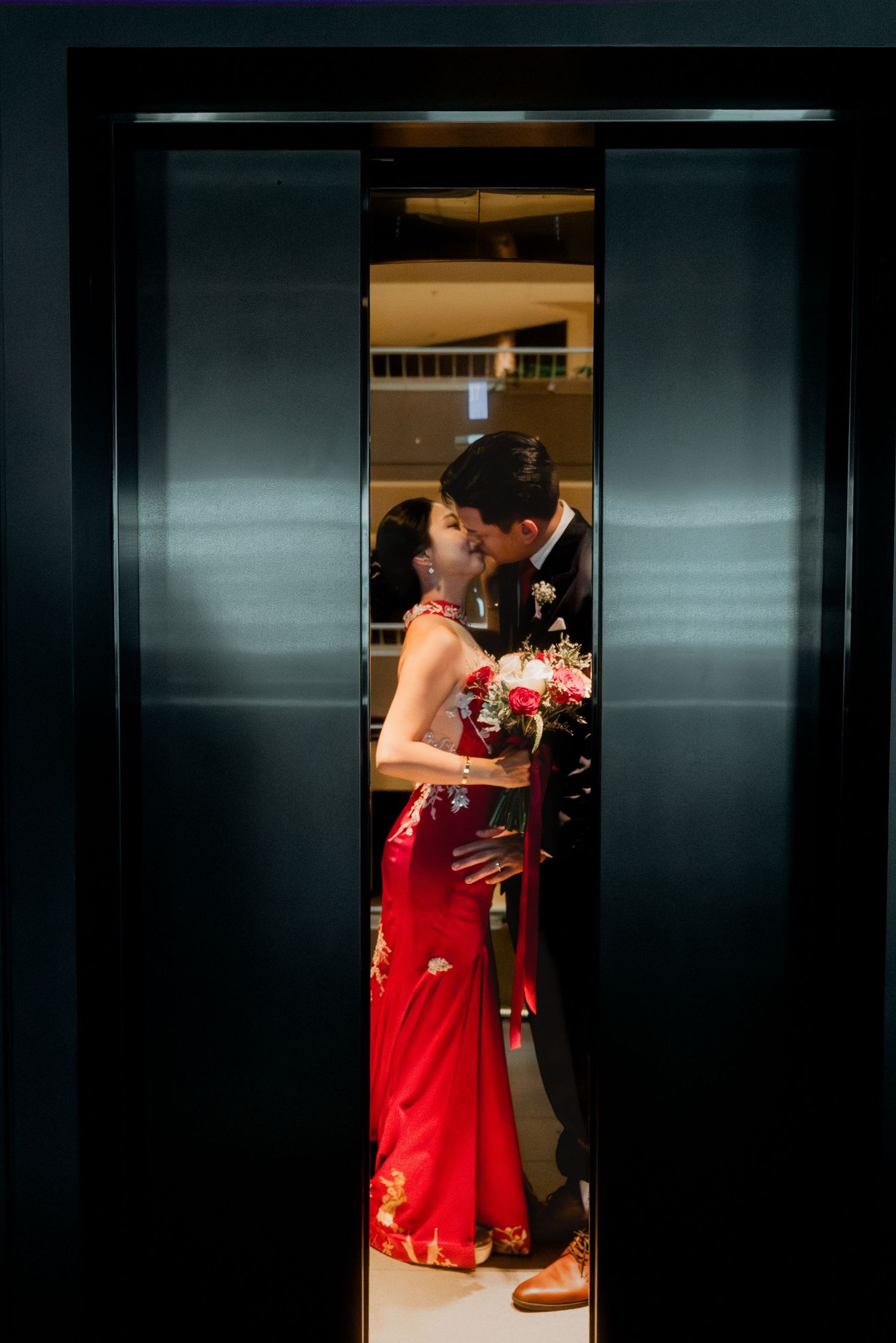 Dramatic elevator scene with couple in formal attire sharing intimate moment. Singapore Pan Pacific hotel