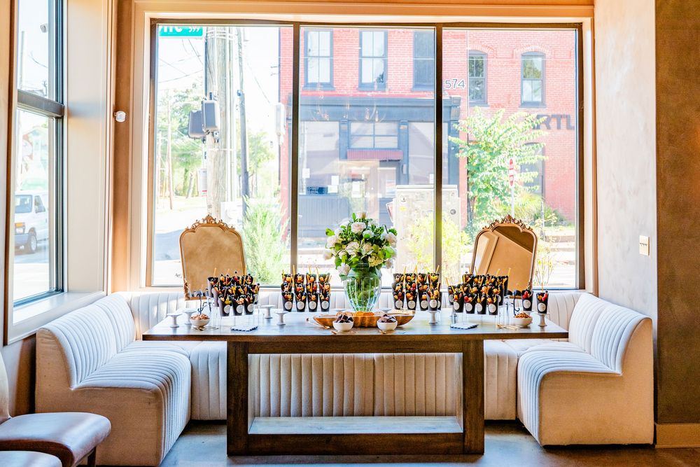 Elegant restaurant booth with floral centerpiece and champagne glasses by a large window.