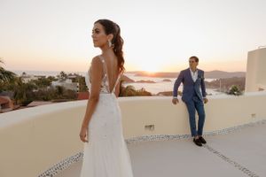Elegant wedding couple on a Mediterranean terrace at sunset overlooking the ocean.