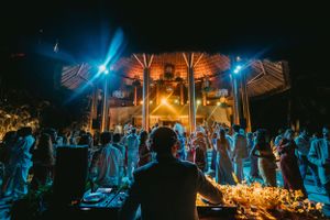 Nighttime wedding reception with blue lighting and dancing guests.