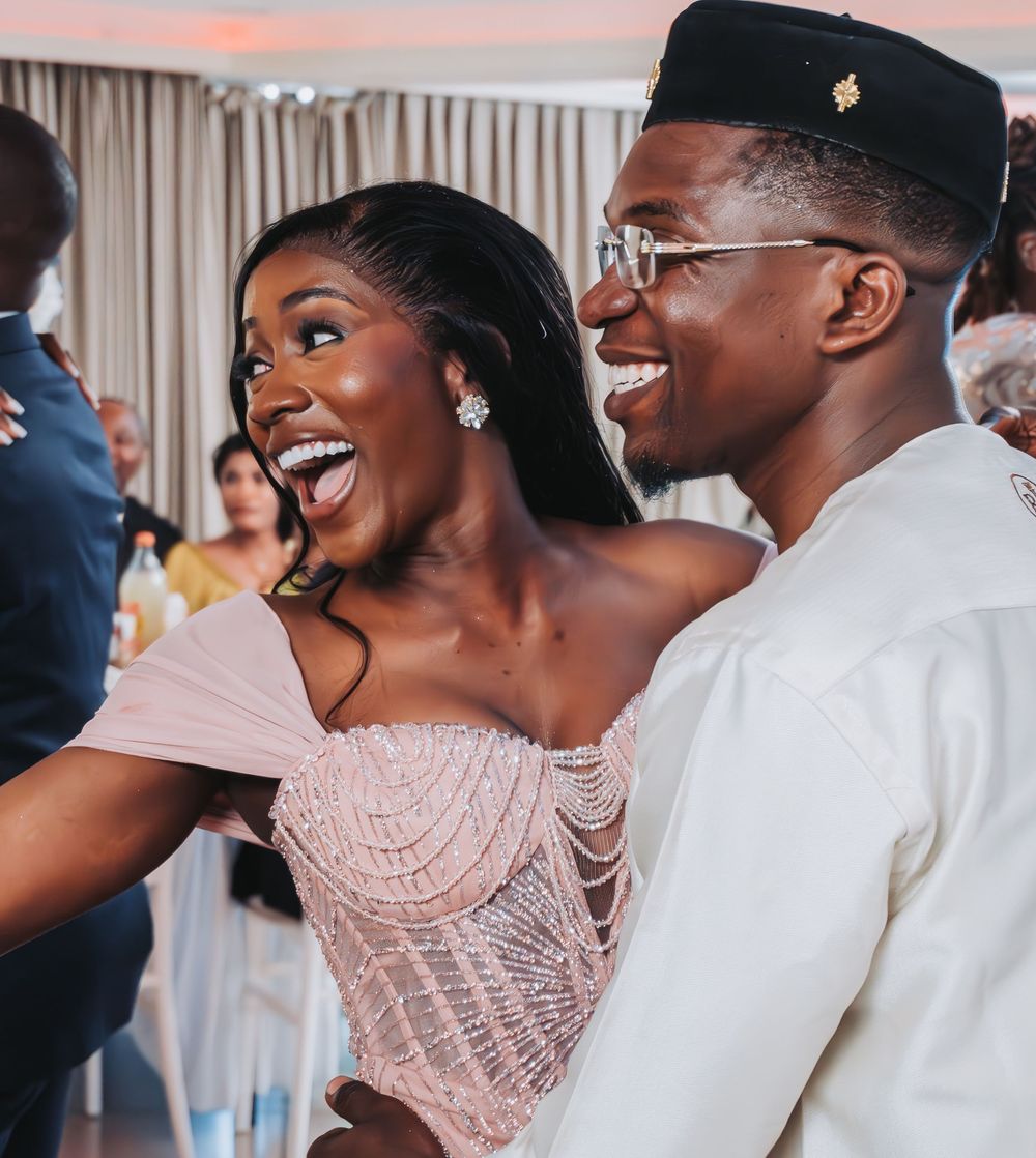 Mariée souriante dansant avec son mari pendant la soirée de mariage