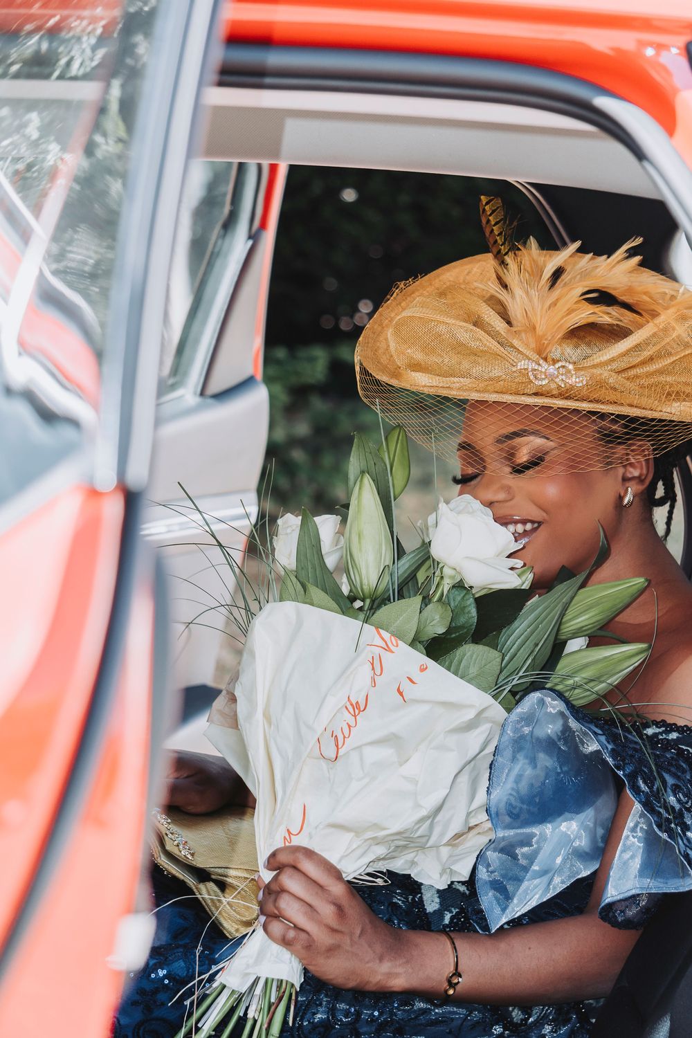Mariée sentant son bouquet dans le véhicule avant la cérémonie civile